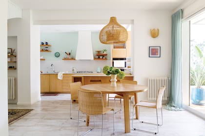 Estantes (BS Carpintería). Muebles de la cocina y barra enchapados en lenga (Raúl Magnarelli). Aplique de pared de cerámica (Sany Cerámicas). Mesa redonda (Mercato). Sillas (Jaim). Lámpara colgante (Compañía Nativa)