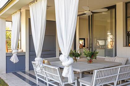 En el comedor exterior, mesa ‘Nino’, bancos ‘Meca’ con almohadones (todo de Nicho).