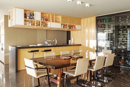 Mesa con patas de madera de iroko y tapa de pergamino laqueado (Eugenio Aguirre). Sillas (Roche Bobois).