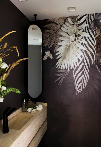 Toilette diseñado por Abstracto Interiorismo con mesada de Travertino con bacha incorporada (@venatomarmoles), largo espejo móvil y empapelado con motivos XL.