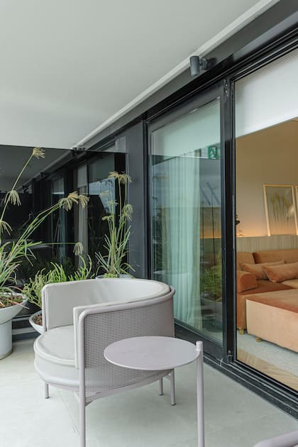 Pisos en porcelanato modelo Adeona Antique (Cerámica San Lorenzo). Iluminación con artefactos Ites y lámpara USB (ambos de Idea Iluminación). Sillón y mesa aptos para exterior (Rahola).