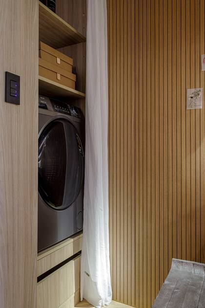 Revestimiento ranurado en panel acústico (Patagonia Flooring). Lavarropas (Drean).