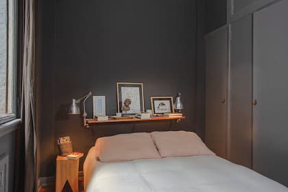 Las paredes están pintadas con ‘Ágata de Islandia’ (Alba). Cortinas de gasa (Hands Off). Lámparas de acero con prensa (Paul French Gallery). Estante de kiri amurado con ilustración de Rosado Tomate, un acrilico en papel (Mery Moon) y un flyer enmarcado del New Museum de Nueva York.