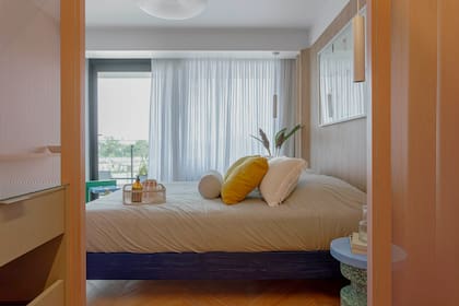 Respaldo envolvente en melamina 'Paraíso' de Faplac (Moi Muebles). El banco 'Ronda' de plástico rotomoldeado tiene una tapa laqueada para usar como mesa de luz (Par en Par).