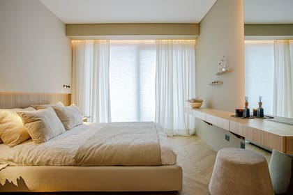 Este minimalista dormitorio diseñado por Paprika es buen ejemplo de cómo usar blackout, cortinas translúcidas y tiras LED bien ubicadas para atenuar o dejar entrar luz en diferentes momentos del día.