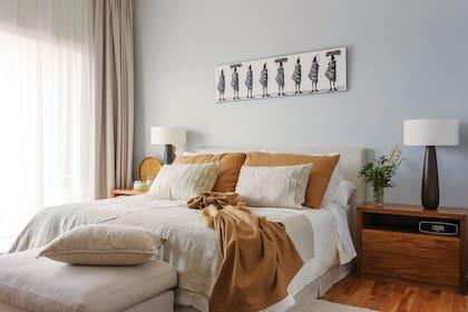 Somier (La Cardeuse), respaldo y cubresomier (Ion Natural); ropa de cama, almohadones y mantas (Indias Argentinas). Mesas de luz de petiribí (Woodmarket), lámparas ‘Baobab’ (Il Mercato) y obra comprada en Sudáfrica. El butacón, tapizado con género de Casa Almacén.