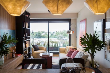 Individuales (Concepto Fusión). Tres lámparas colgantes demarcan el espacio de cocina-comedor del living. Cortinas EverWood® Faux Wood Blinds, color Negro 3110 (Hunter Douglas), motorizadas para domótica.