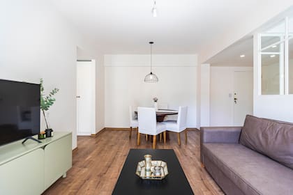 Sobre la mesa, lámpara colgante tipo jaula en negro. La tele se puede ver desde comedor, la cocina y el sillón.