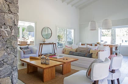 En el living, mesas bajas de petiribí. Sillón (Rancho Deco) con fundas (Ana Bustamante). Almohadones (Puerto de frutos). Sillas y alfombra (Rancho Deco).