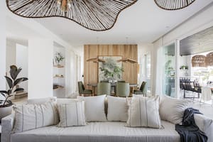 Foto de un living comedor con sillón de tussor, almohadones y lámparas colgantes.