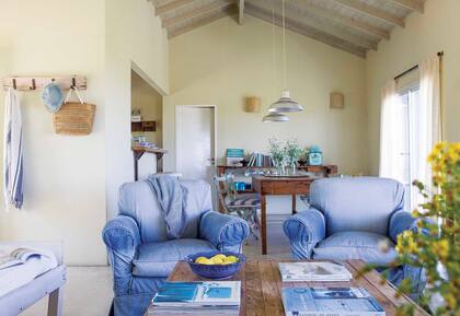 Sillones individuales heredados con fundas de jean (Paula Delledera). Perchero hecho por Matías con maderas de obra. Almohadones (Ana Szarun). Manta de algodón y flecos (Elementos Argentinos).