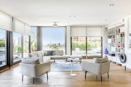 Alfombra de lana, mesas de centro y de arrime (Zanotta). La consola ‘Caruso’ (Miniforms) tiene doble función: es vajillero y mueble de audio, con un atractivo parlante instalado por fuera.