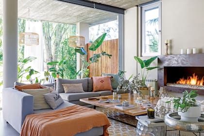 Sillones gris perla con chaise longue (Della Casa). Almohadones (Another Home). Mesa de arrime y taburete color plata (Sol Palou). Velas (Bohemia Velas). Plantas y macetas (Ciudad Naturaleza).