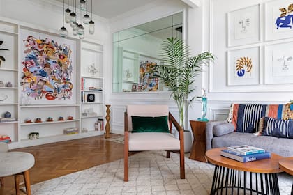 En la biblioteca, acrílico de Andrea Santarelli (Praxis). Sobre la mesita de madera escultura de Gladys Silva. Espejo original del edificio y lámpara de techo de Pottery Barn.