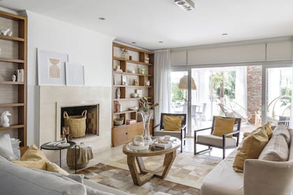 Florero y velas nórdicos (Kala Aromas). Florero alto con magnolias (Las Casianas). Canasto con mantas (Baska Home) y leñero (Puerto de Frutos).