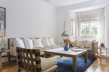 Butacón; sofá grande ‘Gaucho pop’ en madera, rafia y gamuza; sofá chico forrado en lino (todo de Eugenio Aguirre). Almohadones estampados (Mercedes Segura).