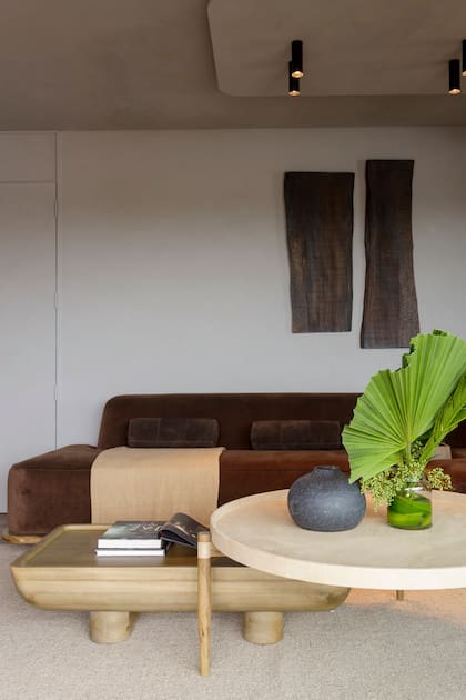 Sillón modular y alfombra tejida en la India (Compañía Nativa). Las mesas, como todos los muebles, fueron hechos a medida por CN Estudio. En lugar de cuadros, dos impactantes piezas de madera.