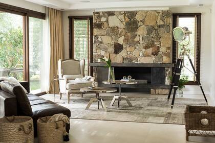 En el living, sillón ‘Marseilles’ de roble platinado y lino, sofá ‘Lincoln’ de cuero, mesas ratonas de altura regulable con patas cromadas y tapa de roble, y lámpara trípode ‘Allen Good’ (todo de Landmark) sobre alfombra patchwork ‘Persia’ (Mihran).