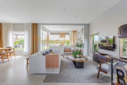 Alrededor de la TV, sillón (Bo-Tikken), almohadones (Woodmarket), manta (Zara Home), alfombra (Ikea), mesa de petiribí y hierro (Q Furniture) y bandeja de mármol ovalada (Quinto Home).