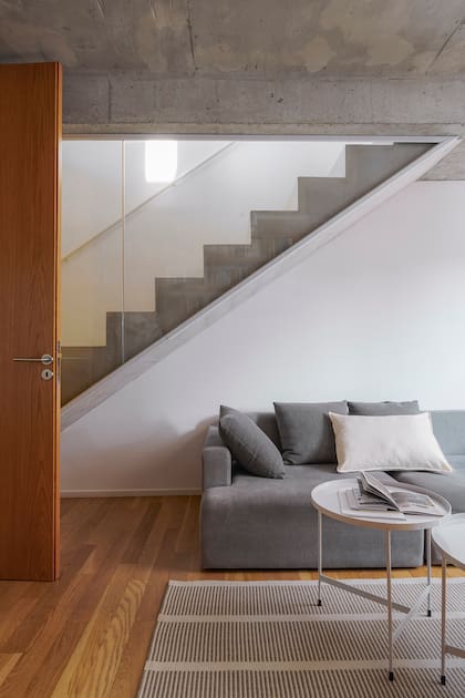 Frente a la biblioteca, sofá para ver series y pelis, y mesas de centro (Tabureto Muebles).