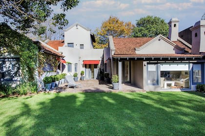 Una reposera espera lista para recibir el sol freente al verde del pasto.