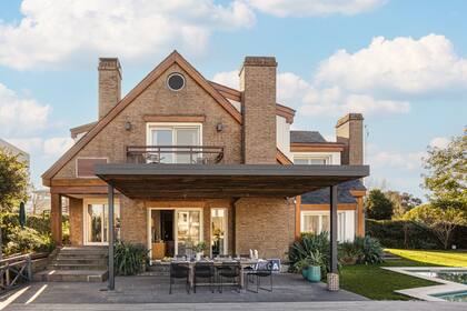 El comedor exterior semicubierto junto a la pileta con forma de martillo.