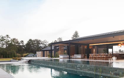 Un desborde infinito lleva a un nivel más profundo de la pileta. En el contrafrente se ubicó también el área húmeda con reposeras y un fogonero.