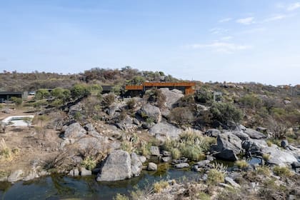 La casa tiene cancha de paddle y pileta hecha en mampostería tradicional, con revestimiento negro simil piedra bali y deck térmico de tablas de hormigón prefabricado.