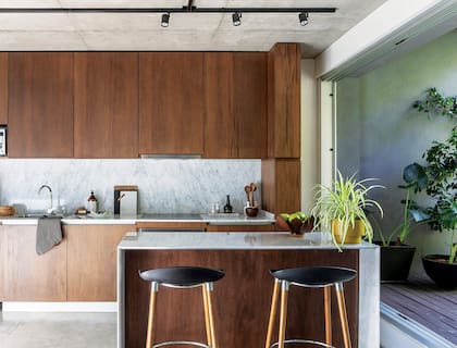 Grifería monocomando (FV). Del extractor (Franke) solo se ve una línea ya que está oculto tras uno de los paneles. Taburetes ‘Milo Wood’ (Diwar Argentina).