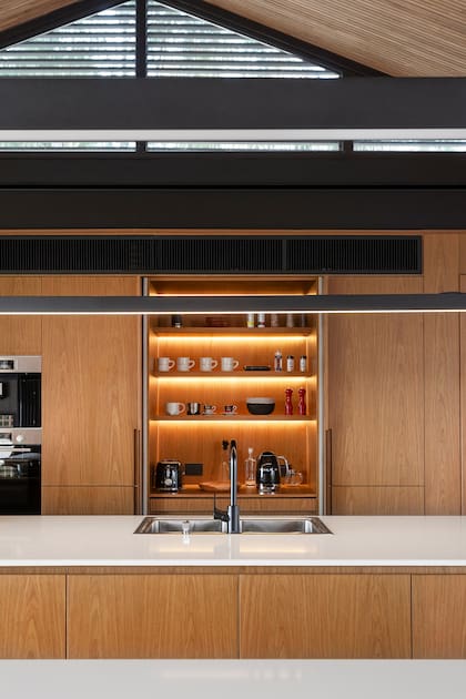 El gran mueble oculta la despensa y el lavadero. Tiene un móduloc on microondas y horno empotrados, y una estación de café que se ve al deslizar las puertas.