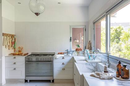 Lámpara de vidrio (Compañía Nativa) para facilitar la limpieza, y un detalle: la misma trama que las del comedor. Piso y zócalos ‘Ecowood Puro’ (Ilva).