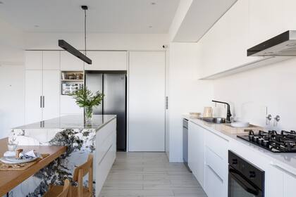 Muebles de cocina laqueados en blanco (Octava Arquitectura) con mesada de granito.