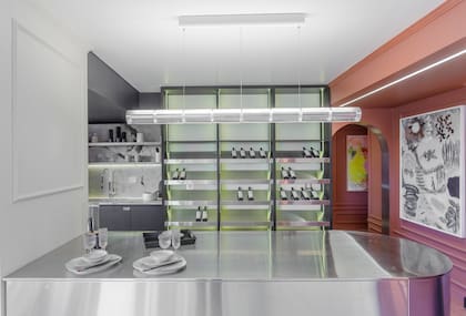 Isla a medida en acero inoxidable (Artefacto). Bodega en Rauvisio Noir (Rehau) y estantes de acero inoxidable (Artefacto, por Dwell). Luminaria 'Luce Orizzontale' de la firma italiana Flos (Griscan). Obra en tonos de gris de Adriana Carambia (Diderot.art).