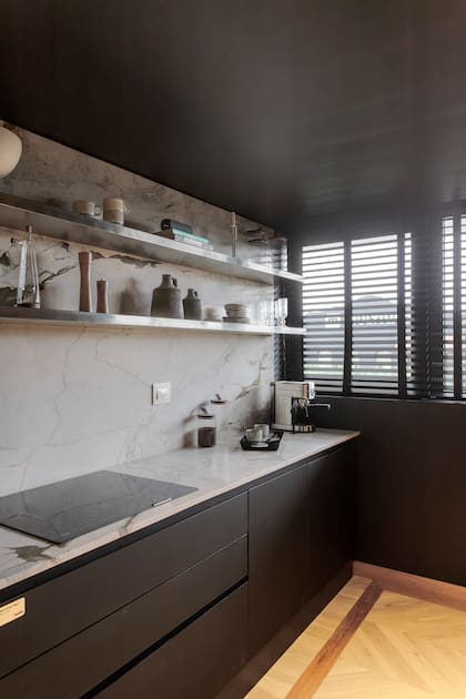 Muebles de cocina en Rauvisio Noir (Rehau) ejecutados por Dwell. Mesada y alzada en cuarcita 'Matarazzo' (De Stefano por Mármoles Milán). Estantes en Acero inoxidable (Artefacto). Anafe a inducción (Teka).