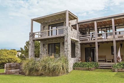 La escultura de un niño hecha por María Lanusse mira al mar y le da identidad a la casa. Los escalones que bajan de la galería hacia el jardín son de hormigón.