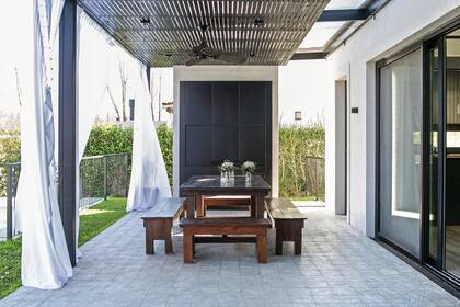 El techo de la galería tiene dos instancias: la estructura de hierro con chapa acanalada, montada sobre las varillas de madera, y una raja junto a la casa para no oscurecer el interior. Las cortinas comparten el estilo con las interiores.