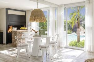 Foto de una galería con mesa blanca, sillas Tólix y parrilla.