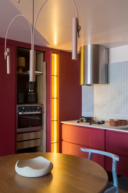 Sobre la mesa, centro de Dukaan Home. Alzada de Neolith 'Retrostone' (De Stefano) trabajado con ranuras. Colgante 'Arañita Pepa' (Fábrica de Luz), que pintaron en color terracota, al igual que varios otros apliques del espacio.