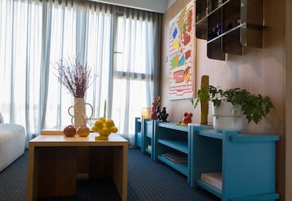 Mesas ratonas “Trípode”, consola celeste “Cruz” y estantería de acero inoxidable (todo Par en Par). Alfombra (Rugit). Cortinas Hunter Douglas by Mercado Design.