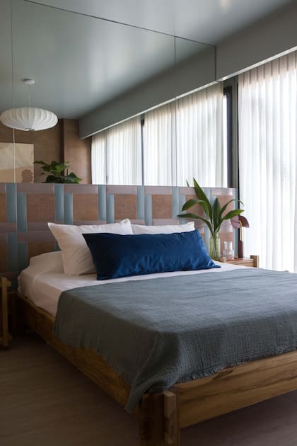 Los textiles elegidos para la cama (Lote Propio) juegan con los tonos del respaldo.Cortinas Hunter Douglas (Mercado Design).