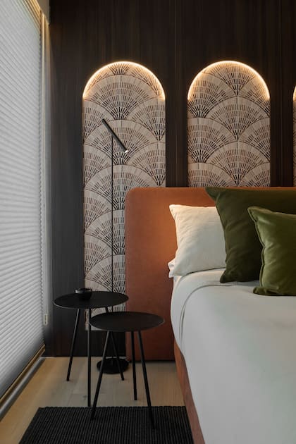 Los arcos se remataron con cintas led, dándole impacto visual al empapelado, que retoma los tonos generales del departamento. Lámpara de pie 'Wipi' (IDEA).