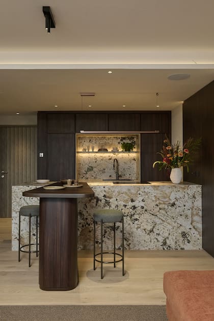 La mesa-barra y los muebles de cocina, diseño de Halesa Estudio ejecutados por Casa Leiro. Puerta de entrada (Oblak). Objetos deco (Casa Clara).