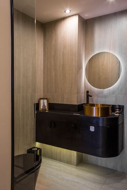 En el toilette, espejo (Reflejar Espejos), grifería de la línea “Cilindra” y accesorios “Clip” en negro mate (FV). Bacha “Mola” (Ferrum). Mesada en “Negro Grafito” con terminación “Leather” (De Stefano).