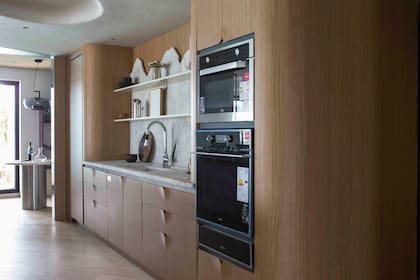 Mesada y alzada con gran textura en granito "Patagonia", en terminación "Deep" (De Stefano, desarrollada por Ital Piedras). Bacha armada en la misma piedra. Hornos (Tekka).