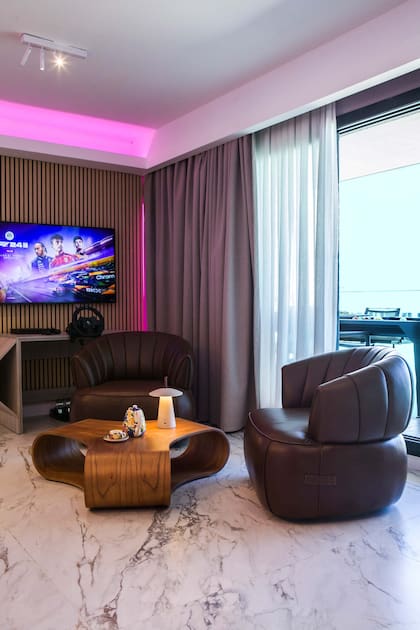 Revestimiento de pared (Patagonia Flooring). Porcelanato “Breccia Capraia Blanco” satinado (San Lorenzo Design). Mesa y sillones (Lumare).