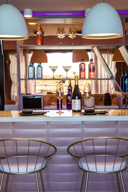 Barra revestida en cerámica “Ombre Lady Blush” (San Lorenzo Design). Vajilla y objetos deco (Tutto per la Casa). Banquetas (Zambia). Bebidas (Fullescabio).