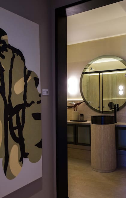 Piso, revestimiento, mesada y vanitory curvo de travertino "Ivory" a la veta, desarrollados por Marmolería Pietrostone. Grifería en negro mate (FV). Bacha circular (Ferrum).