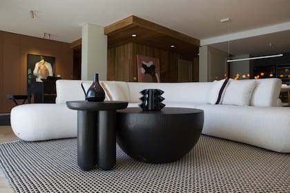 El impactante sillón curvo es un diseño de Revestir ejecutado en Brasil por el estudio Serra Gaucha (Revestir). Mesas bajas y piezas de cerámica de Arte Raku (El Camino Studio). Alfombra (Rugit).