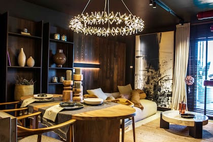 Juego de comedor, vajilla, lámpara colgante y objetos decorativos (Loly Albasini). Revestimiento de pared (Patagonia Flooring). Obra de Luisa Jaca (Diderot.art).