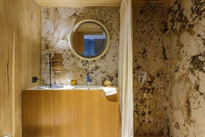 El revestimiento de las paredes del baño principal es en Purastone Prima 'Alphinus' (De Stefano). Cielo raso en madera.